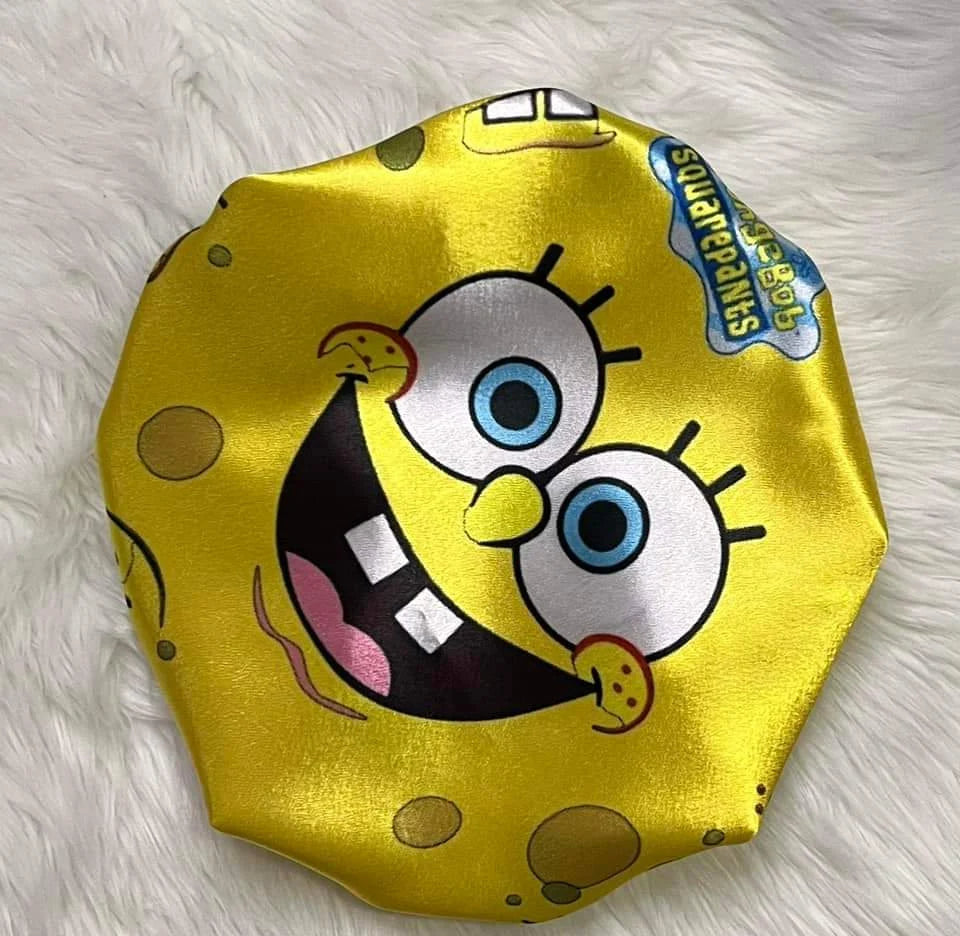 Yellow side of the Cartoon Besties reversible satin bonnet